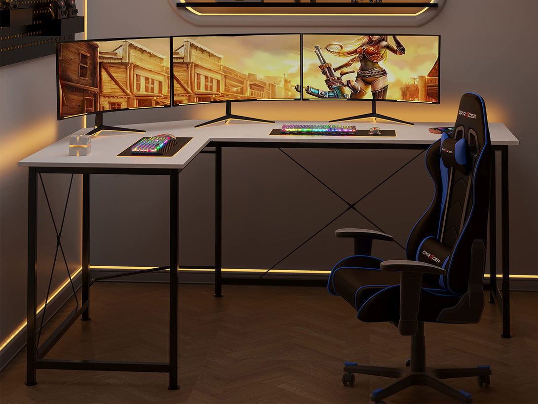 Kestrel Computer Corner Desk in White with L-shaped design, triple monitor setup, keyboard, and gaming chair.