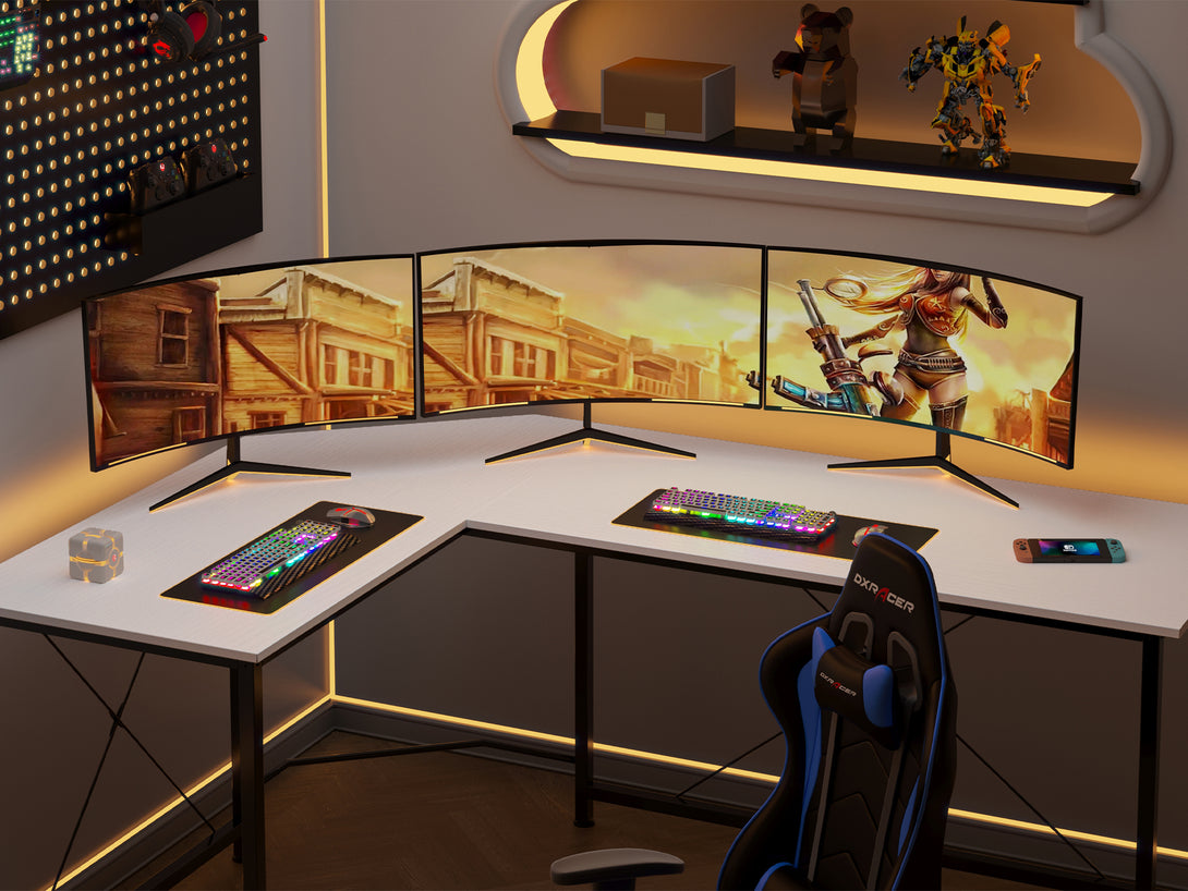Kestrel Computer Corner Desk in white featuring an L-shaped design, gaming setup with three monitors and colorful keyboard.